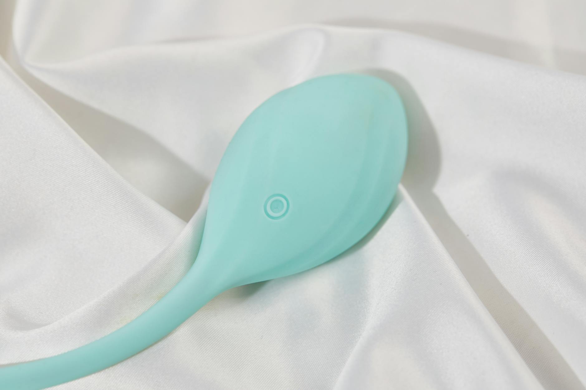 Frau hält einen blauen und rosa Vibrator nachdenklich in den Händen