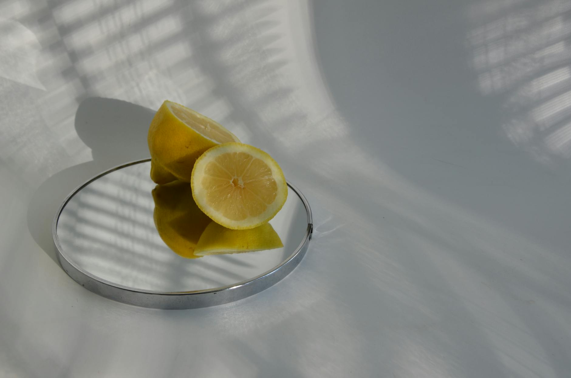 Halbierte Zitronen auf einem Spiegel mit Schatten, das die Frische von Menopause und Neuanfang symbolisiert