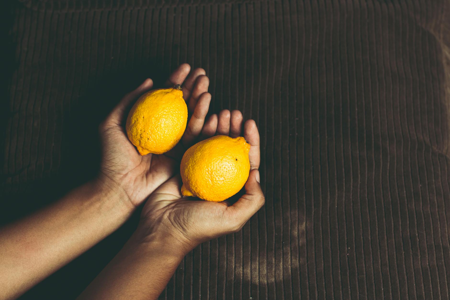 Hands holding fresh lemons, symbolizing hormonal sensitivity and renewal