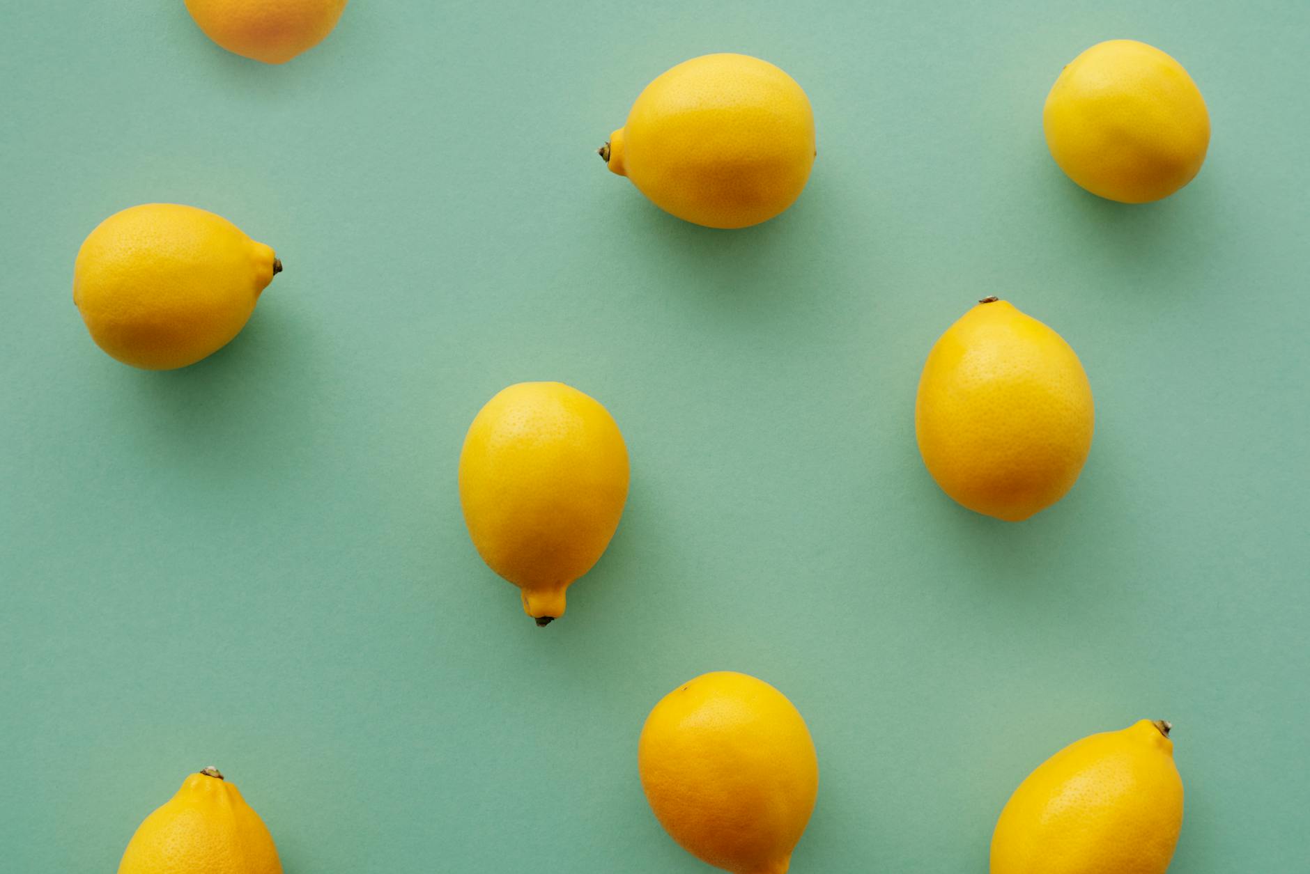 Bright yellow lemons arranged on a pastel green background, symbolizing the fresh sensation of clitoral suction stimulation.