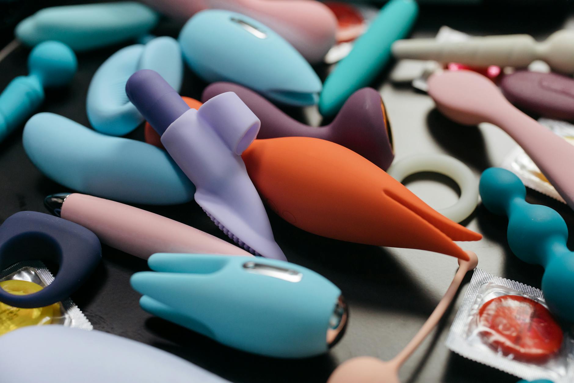 Eine Frau hält einen rosa Vibrator in der Hand, Kunstbücher im Hintergrund, Intimität im Fokus.