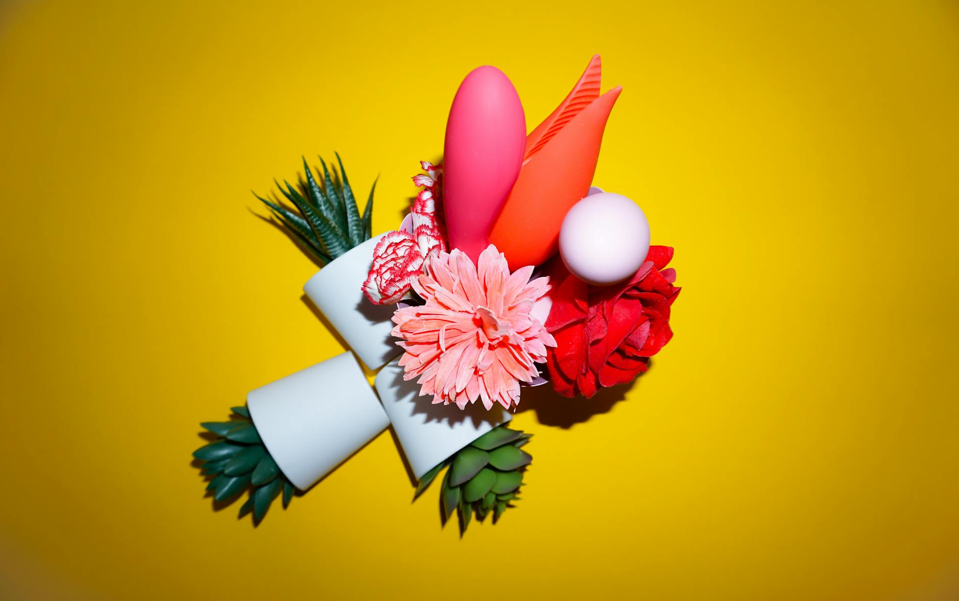 Colorful arrangement of flowers and abstract objects on a bright yellow background.